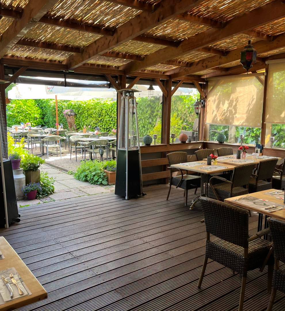 De lichte overkapping en tuin van Eetcafé De Nar